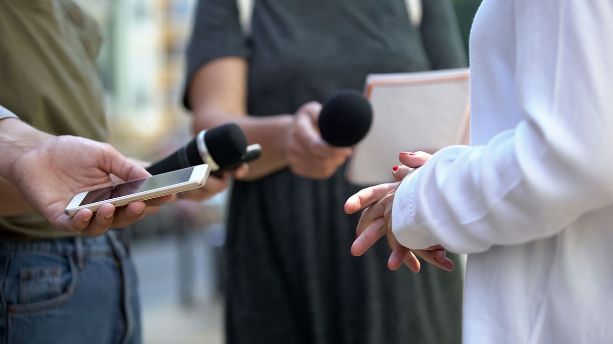 Close up of someone holding phone and others holding microphones
